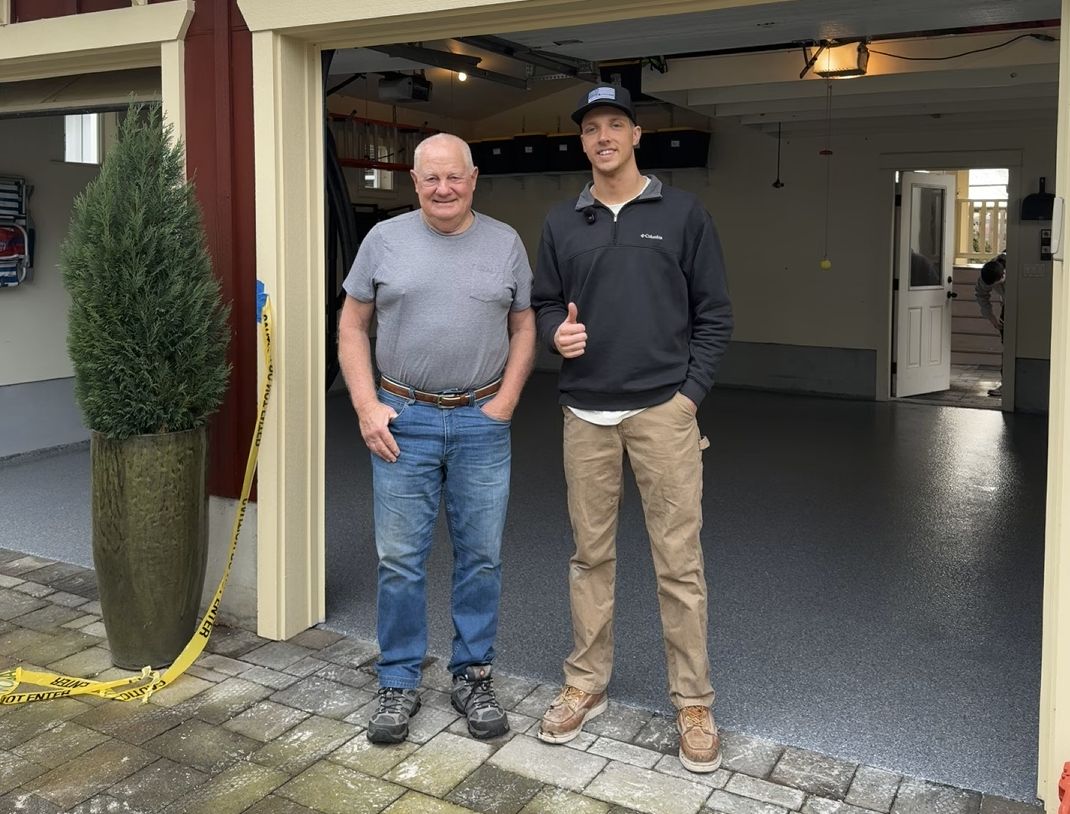 Evergreen Epoxy owner with a happy customer in front of their new flake garage floor