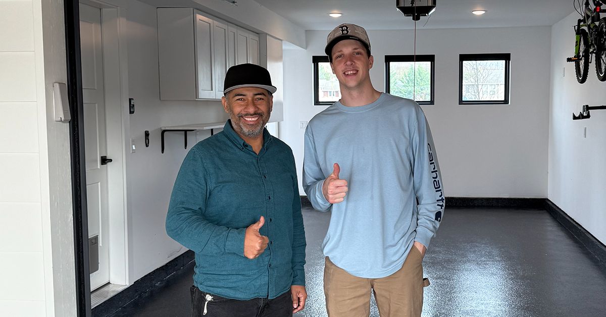 Evergreen Epoxy owner with a happy customer on their new dark epoxy floor