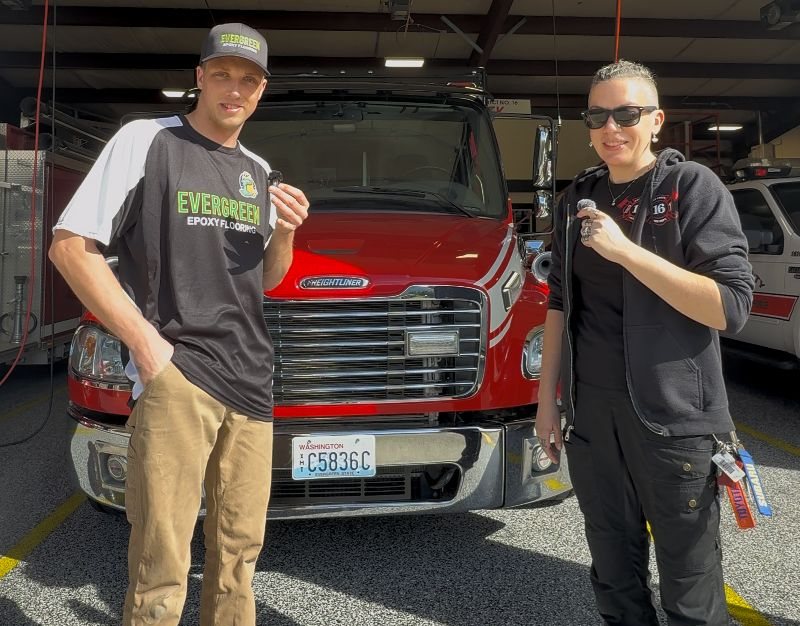 Evergreen Epoxy owner with a firefighter on the station's new flake floor
